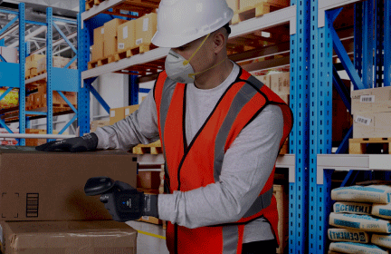 Image of text and a worker wearing gloves while scanning barcode in a factory setting