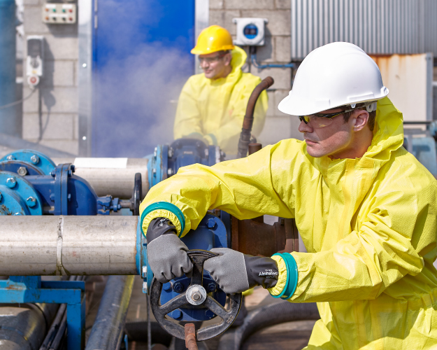 Image of 2 workers in an oil rig wearing Ansell's chemical protective clothing
