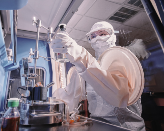 Image of a worker wearing Ansell's gloves while inspecting plane parts in an aerospace facility