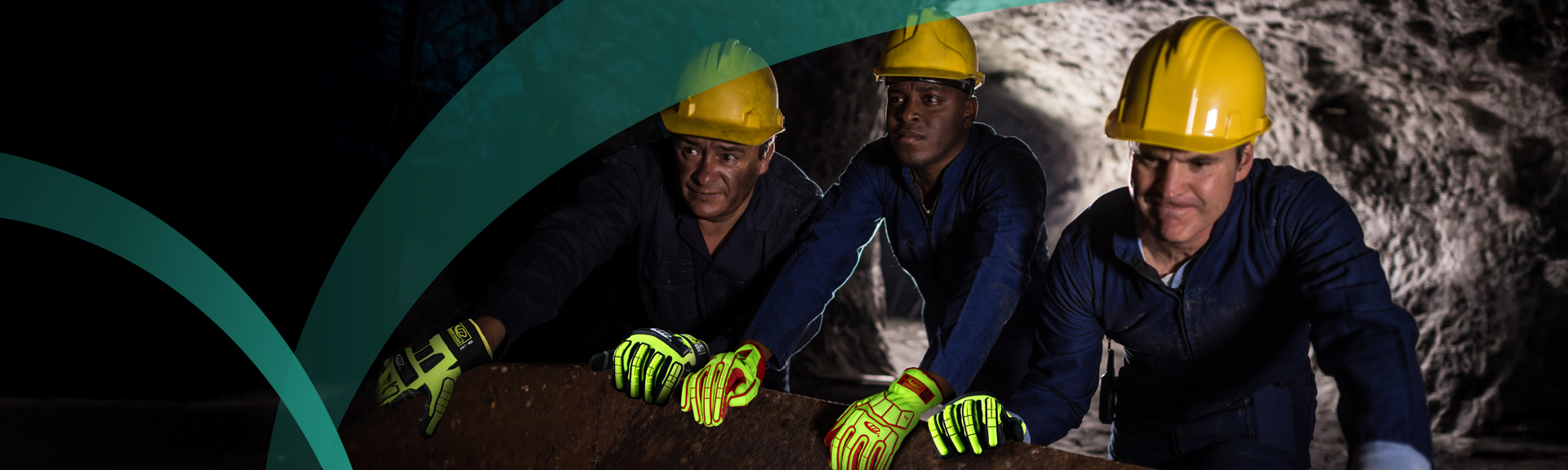 Miners wearing yellow hard hats and high-visibility cut-resistant gloves working underground in a mining tunnel.
