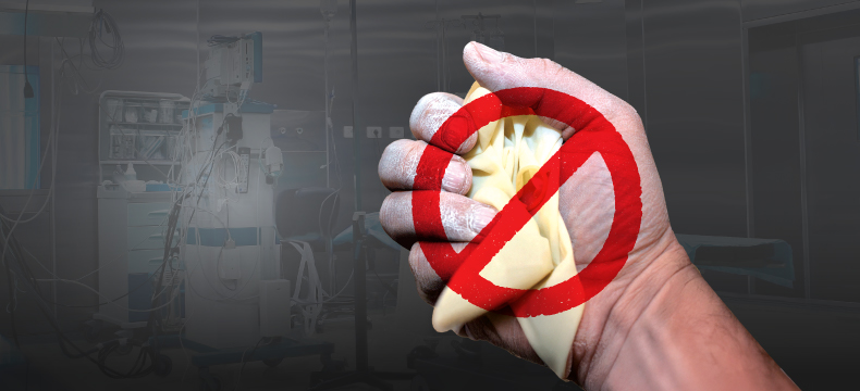 Image of a healthcare professional’s hand holding powdered gloves with a ban sign representing ban on powdered gloves in healthcare