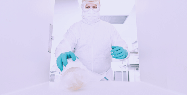 Image of a cleanroom worker in a cleanroom environment with full cleanroom garment and cleanroom gloves