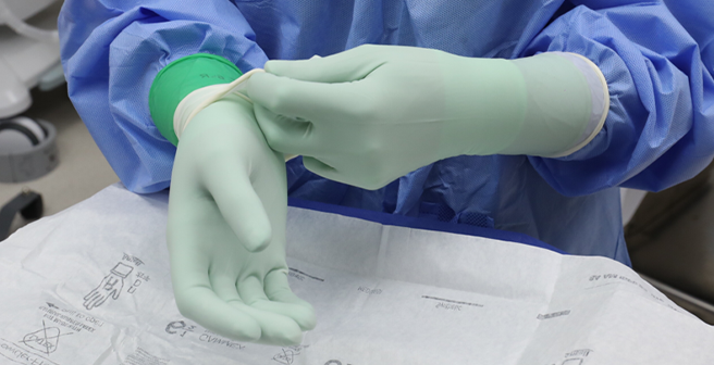 Proper donning and doffing techniques, along with the use of a two-color double gloving system, support barrier integrity and help detect glove breaches during procedures.