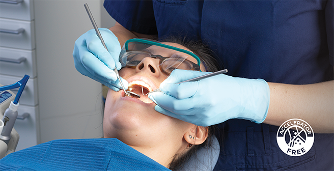 Image of a dental professional treating his patient while wearing accelerator-free gloves to ensure allergy prevention