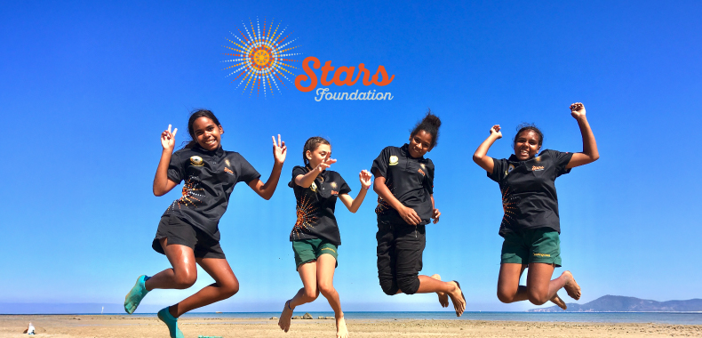 Group of aboriginal girls from the Stars Foundation jumping together in celebration of empowerment and opportunity.