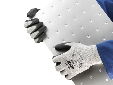 Operator wearing EDGE® 48-701 mechanical gloves handles an iron sheet, ensuring safe grip and careful positioning during transport