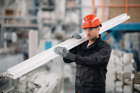 Operator wearing EDGE® 48-707 mechanical gloves handles a steel axle, ensuring safe grip and careful positioning during transport