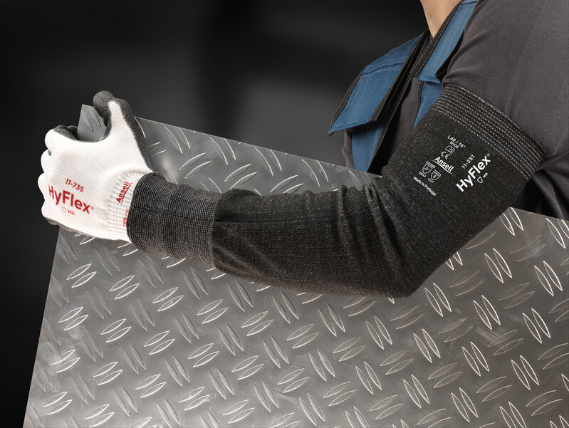 Worker in HyFlex® 11-735 protective gloves and HyFlex® 11-251 sleeves holds a textured metal sheet, ensuring a firm grip while handling heavy materials