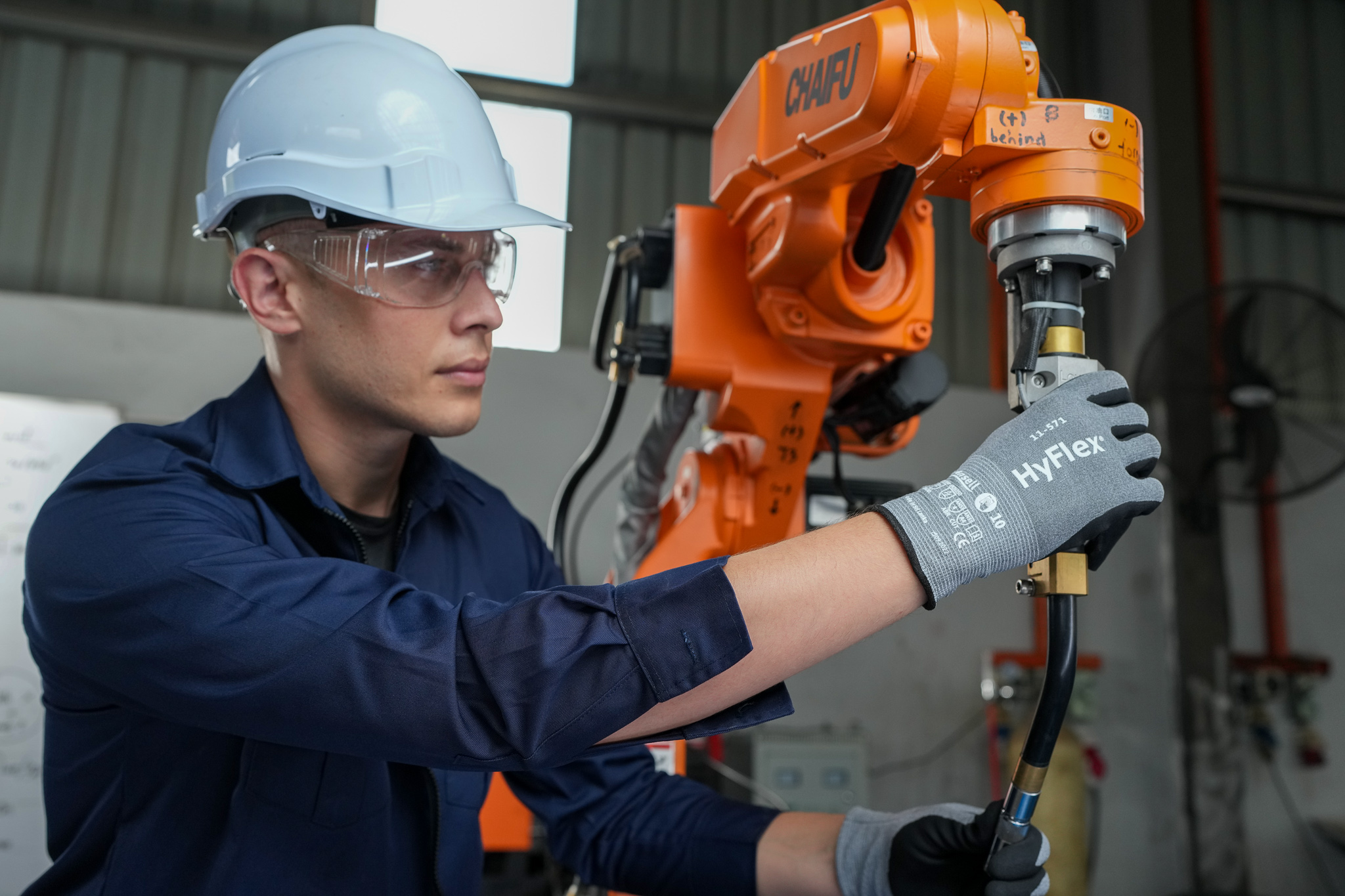Operator prepare a machinery while wearing HyFlex® 11-571 mechanical gloves for protection and precise handling.
