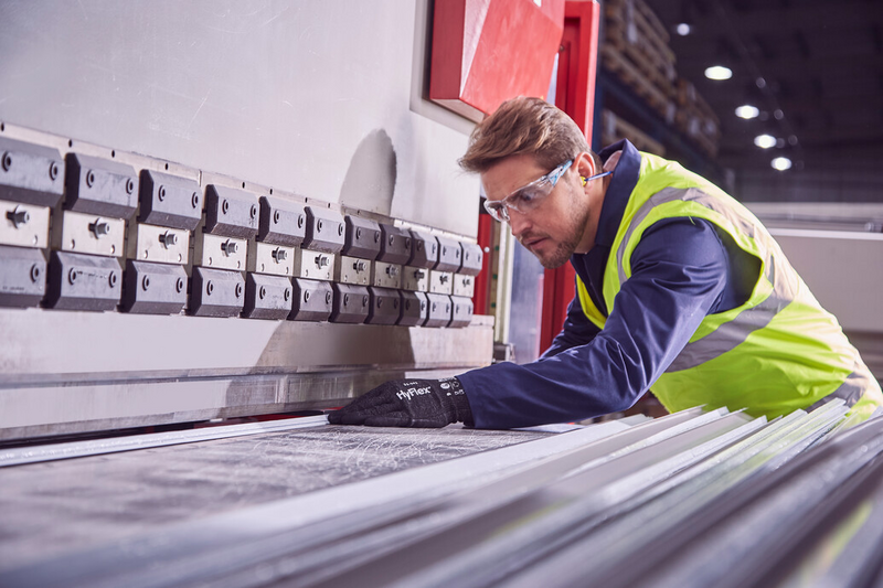 Operator wearing HyFlex® 11-591 mechanical gloves handles a panel, ensuring safe grip and careful positioning