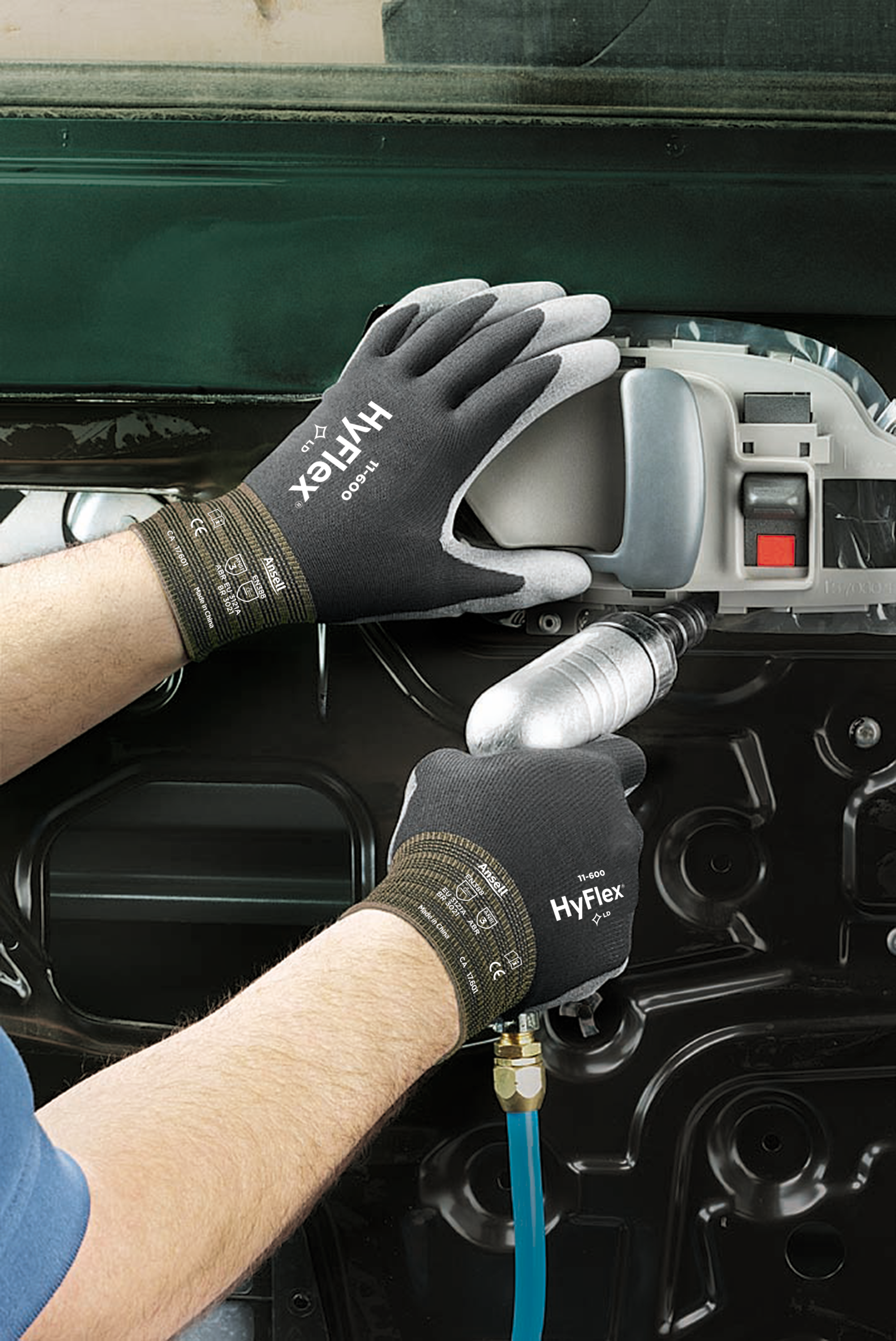 Worker using HyFlex 11600 mechanical gloves while operating a power tool on a metal component.