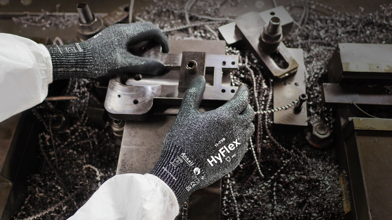 Worker wearing HyFlex 11-738 mechanical gloves, performing maintenance on machinery.