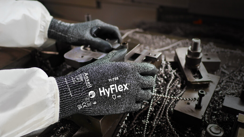 Worker wearing HyFlex 11-738 mechanical gloves, performing maintenance on machinery.