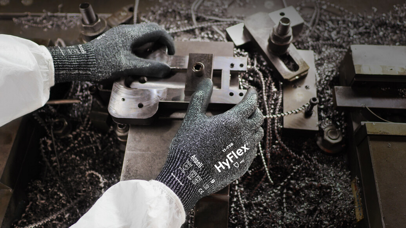 Worker wearing HyFlex 11-738 mechanical gloves, performing maintenance on machinery.
