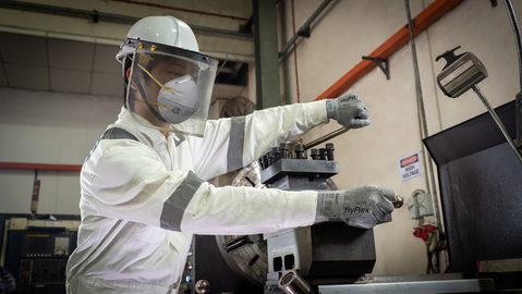 Worker operates machinery while wearing HyFlex® 11-755 mechanical gloves, ensuring safe and precise handling in an industrial setting