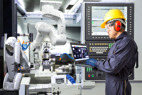 Worker wearing HyFlex® 11-819 ESD mechanical gloves operates a computer to review tool settings, ensuring safety and efficient adjustments