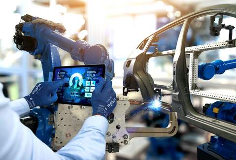 Worker uses a tablet withHyFlex® 11-819 ESD  mechanical gloves to adjust machine engine settings, maintaining control and accuracy