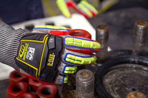 Hand wearing R-065 mechanical glove tightening a bolt 