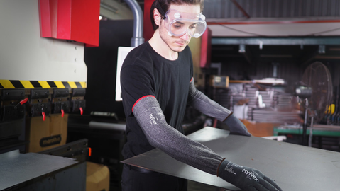 Operator wearing HyFlex® 11-281 sleeves handles a panel, ensuring safe grip and careful positioning during transport