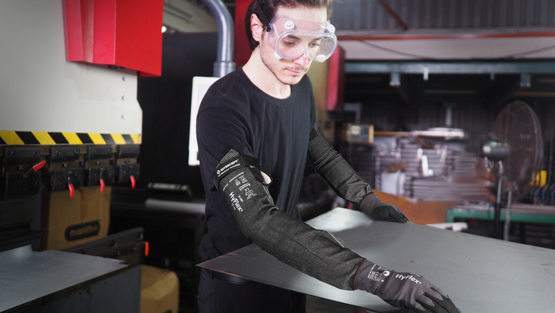 Operator wearing HyFlex® 11-281 sleeves with velcro handles a panel, ensuring safe grip and careful positioning during transport